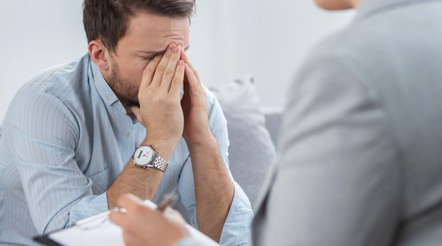 Man holding hands on eyes and face during Dialectical behavior therapy for BPD