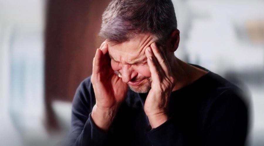 Image of man in pain holding hands on his forehead - Alcohol Withdrawal Symptoms