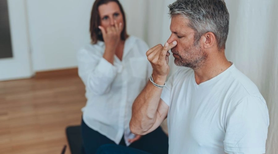 Male patient with counselor behind him practicing Deep breathing exercises