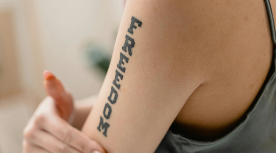 Image of the word FREEDOM tattooed on a shoulder - Recovery Words and Mantras - Eating Disorder Recovery Symbols