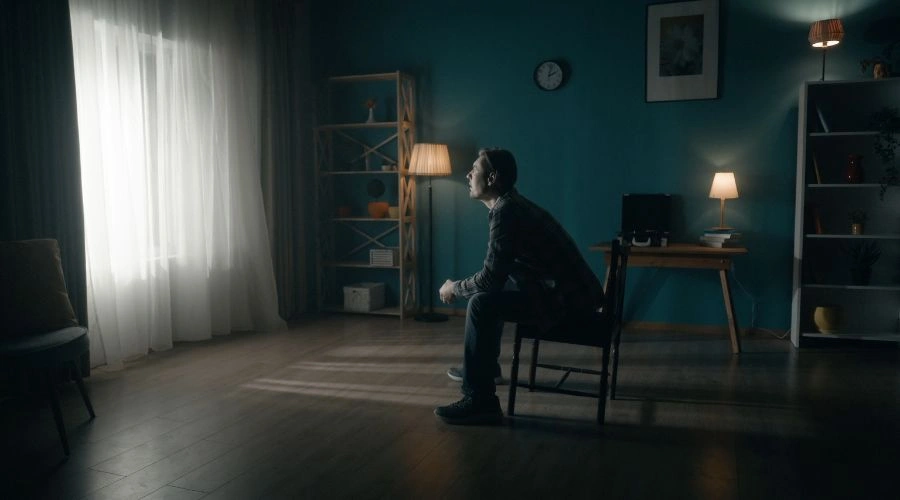 A man sits on a chair and practices the name and describe exercise