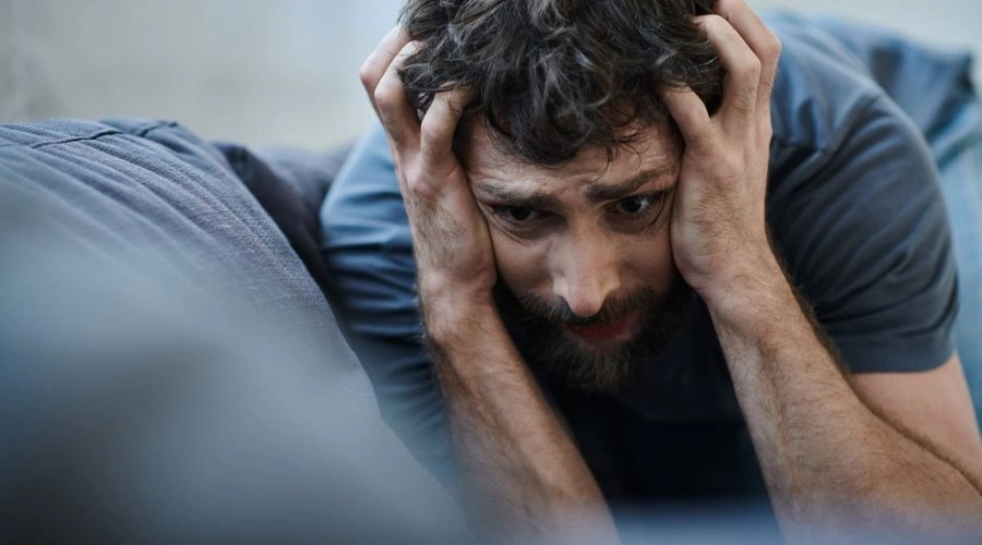 Image of an extremely distraught man holding his hands on the sides of his face - Episodic Schizophrenia Symptom - Catalina Behavioral Health