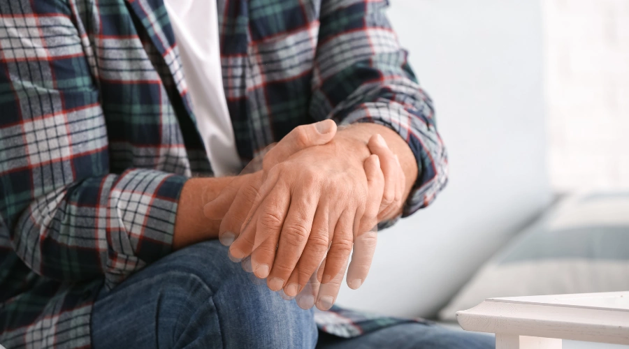 Image of man with schizophrenia and the motor dysfunction symptom of  his hands fervently shaking
