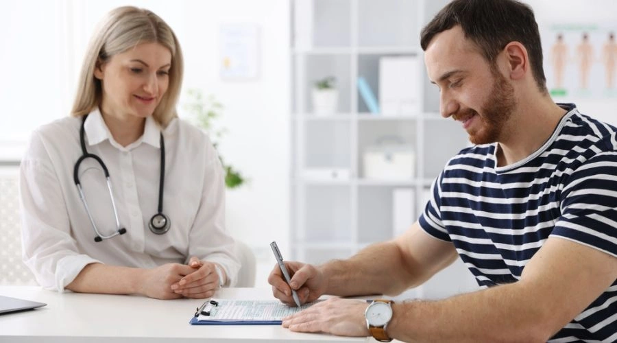 Image of a female physician watching a male patient complete a form - Schizophrenia Treatment at Catalina Behavioral Health