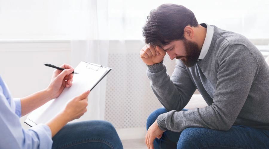 Clinician reviewing mental health assessment forms with a client during the SMI determination process in Arizona