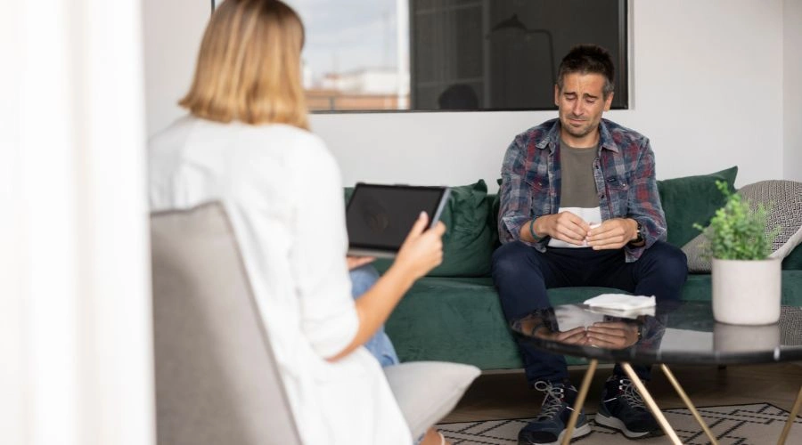 Image of a man with SMI sitting in therapy with his counselor - How to Apply for SMI in Arizona - Catalina Behavioral Health