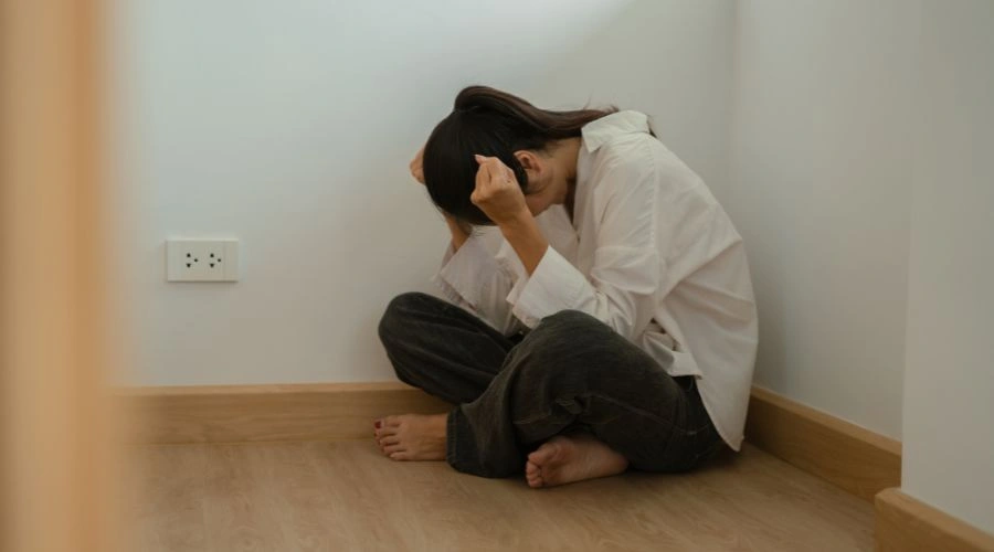 Person sitting alone looking distressed, representing emotional shutdown and feelings of isolation