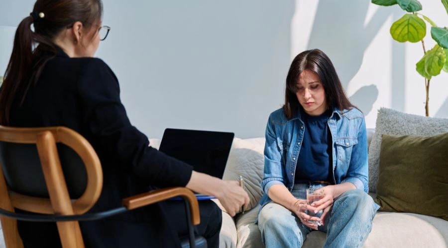 Therapist working with a client in-person, helping her build emotional awareness and manage stress during emotional shutdowns