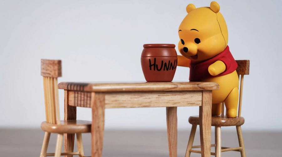 Image of Winnie the Pooh smiling while holding a honey pot, symbolizing the Pooh Pathology personality test theme