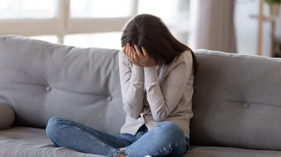 Image of a person sitting alone, looking distressed to visually represent someone experiencing mental health challenges