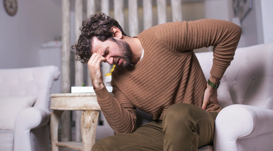 Image of a person holding their head symbolizing chronic pain, tension, and physical symptoms associated with PTSD